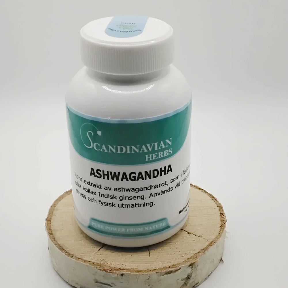 A white bottle of Scandinavian Herbs Ashwagandha - bra vid stress och trötthet rests on a circular wooden platform, showcasing a label with turquoise accents and Swedish text, indicating it contains Withania Somnifera root extract, vital in Ayur Veda traditions.