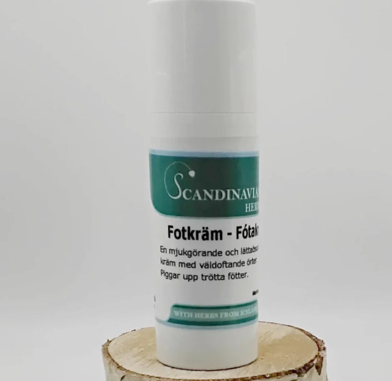 A cylindrical Scandinavian Herbs Fotkräm container with a pump dispenser sits on a wooden base, labeled in Swedish. It mentions herbs from Iceland for sprucken hud treatment.