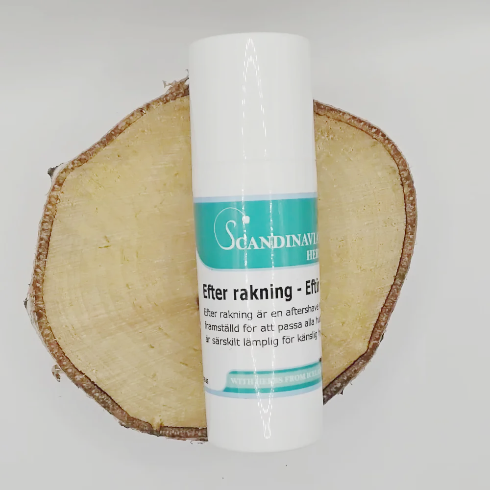 A white bottle of Scandinavian Herbs Efter rakning kräm - after shave rests on a round wood slice. The label features teal hues and white and black text, emphasizing its design for känslig hy. Enriched with naturliga oljor, it provides soothing care after rakning.