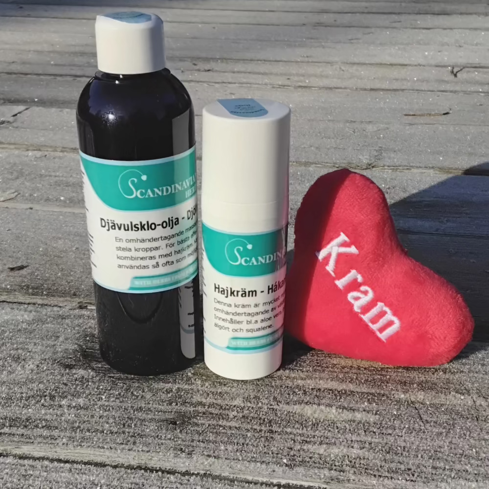 Two bottles with green labels sit on wooden planks beside a red heart featuring Kram. Nearby, Scandinavian Herbs Friskvårdspaket - för stela och ömma leder offers ledsmärta relief, all artfully displayed under sunlight on textured wood.