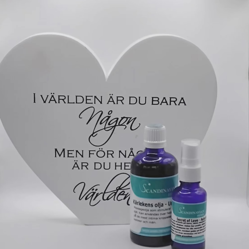 A heart-shaped sign with Swedish text beside two bottles labeled Scandinavian Herbs. The sign reads, I världen är du bara någon, men för någon är du hela världen, meaning In the world, you are just someone, but for someone, you are the world. Try Kärlekspaket – en relationshöjare.