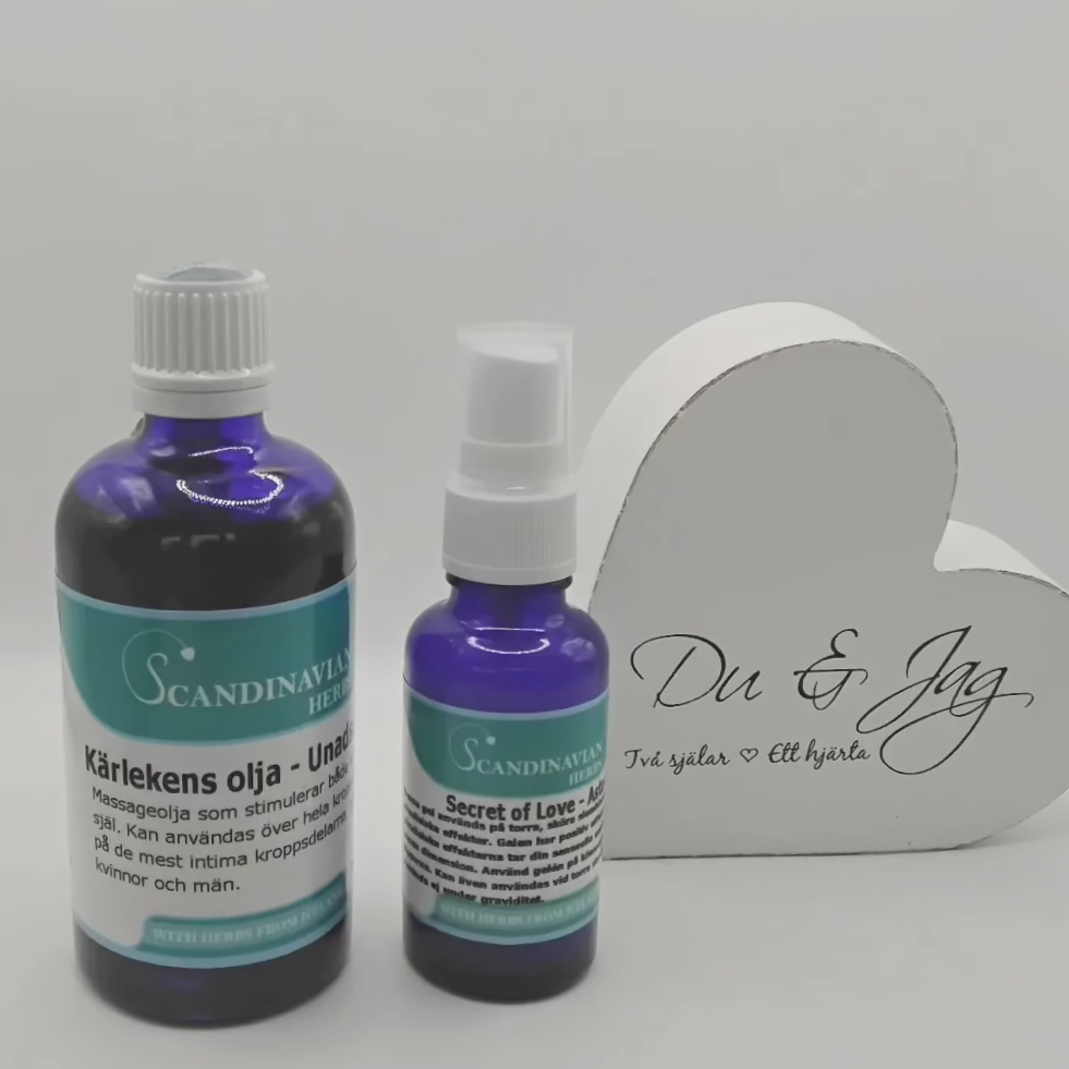 Two blue bottles from Scandinavian Herbs are placed beside a heart-shaped white box with Du & Jag and Två själar Ett hjärta. The larger bottle is labeled Kärleksolja, known for its afrodisiaka effekter, while the smaller is named Secret of Love, all part of the Kärlekspaket- en relationshöjare.
